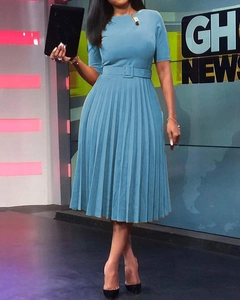 Detail of short sleeve light blue pleated dress featuring a round neck and waist belt