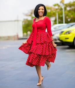 Detail of red tiered polka dot dress with square neck and bow tie on outdoor model