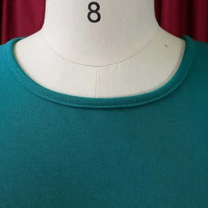 Detailed close-up of the crew neck and fine knit texture on a teal summer dress