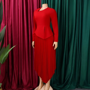 Detail of red asymmetrical neckline and peplum waist on long sleeve pleated midi dress
