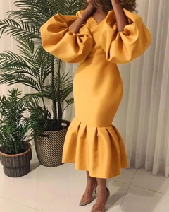 Detail of elegant mustard yellow puff sleeve fishtail dress with a deep V-neckline cut