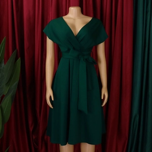 Detail of elegant dark green V-neck dress with waist tie and pleated A-line skirt