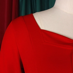 Close-up of neckline stitching on red polka dot plus size dress showing fabric texture