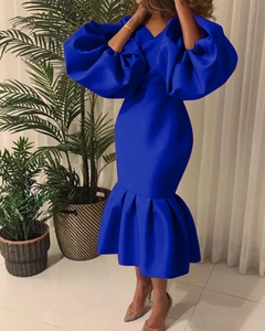 Detailed view of royal blue dress with puffed long sleeves and ruffled fishtail hemline