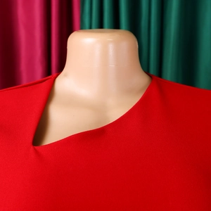 Close-up of elegant red dress featuring a unique asymmetrical neckline and premium fabric