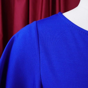 Detail of round neckline and sleeve seams on a royal blue bodycon professional dress