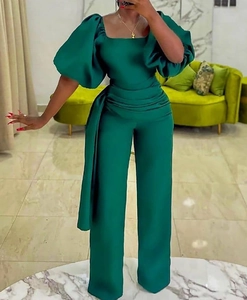 Detail of forest green satin jumpsuit featuring oversized puff sleeves and high waist