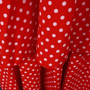 Detail view of red and white polka dot fabric with layered ruffle hem stitching