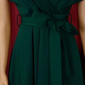 Detail of dark green dress waistline featuring a matching fabric belt and bow tie