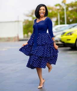 Detail of navy long-sleeve dress with bow neck and tiered white polka dot skirt