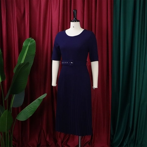 Detail of short sleeve dark blue pleated dress featuring a matching eyelet waist belt