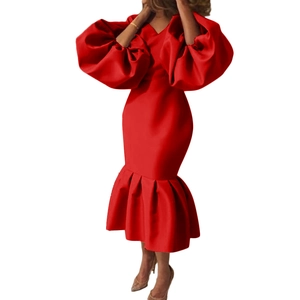 Detailed view of puff sleeves and ruffled fishtail hem on a red satin evening dress
