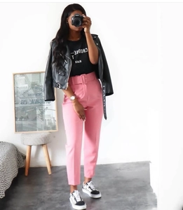 Detail of pink high-waisted wide-leg trousers with matching belt and side pockets