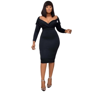 Détail d'une robe midi noire à col en V avec plis aux épaules et broche en strass