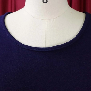 Detailed view of the crew neck and fine stitching on a dark purple short-sleeved dress