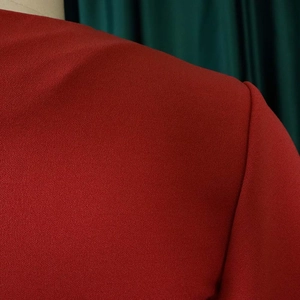 Detail of the ruffle sleeve seam on a dark red V-neck pleated plus size chiffon dress