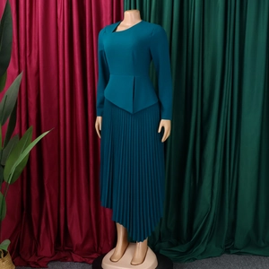 Detail view of peacock blue long sleeve dress with asymmetric hem and pleated skirt