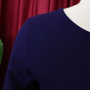 Detail of round neckline and textured fabric on dark purple short sleeve pleated dress