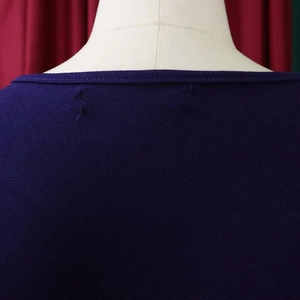 Detailed macro view of the dark purple pleated dress neckline with high-quality stitching