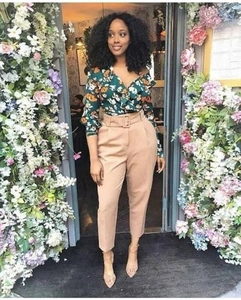 Close-up of khaki high-waisted dress pants with matching square buckle belt and floral blouse