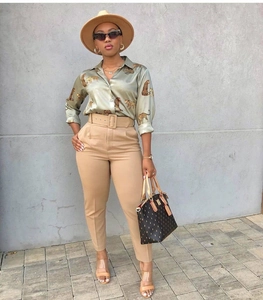 Detail of satin leopard print shirt with high-waisted belted khaki trousers outfit