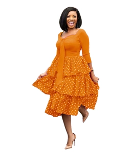 Detailed view of orange polka dot tiered dress with stylish bow tie neckline and long sleeves
