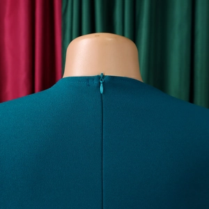 Detail view of the teal dress featuring a high-quality invisible zipper and knit texture