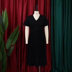 Detail of V-neck black pleated dress with butterfly sleeves and matching square buckle belt
