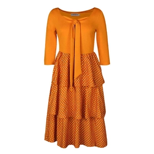 Close-up of orange long-sleeve dress with bow neckline and white polka dot tiered skirt