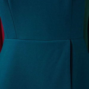 Detail of high-waist seam and gathered pleats on dark teal elegant dress fabric