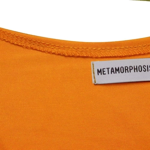 Macro detail of the orange knit fabric neckline with Metamorphosis brand woven label