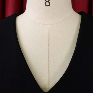Detail of minimalist fine golden chain necklace displayed on a mannequin with V-neckline