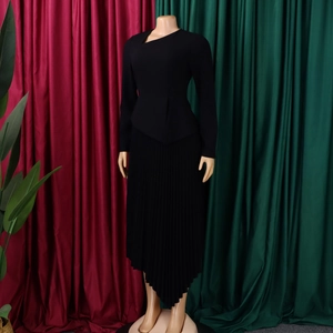 Detail of elegant black slim-fit midi dress featuring an asymmetrical neckline and pleated hem
