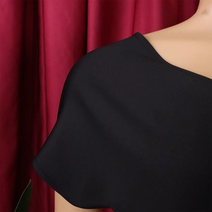 Detailed close-up of the elegant deep V-neckline on a black maxi dress with soft fabric
