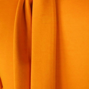 Detailed close-up of the orange-yellow textured fabric with soft vertical drapes