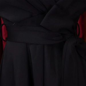 Detailed view of the knotted black waist belt and soft pleated fabric of the dress