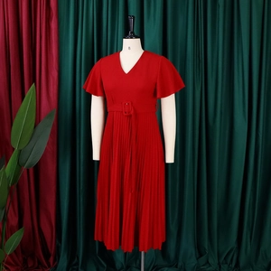 Close-up of red V-neck pleated dress featuring ruffled sleeves and a matching square buckle belt