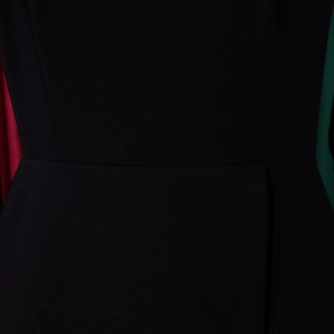 Macro shot of high-waist stitching and textured fabric on an elegant black midi dress