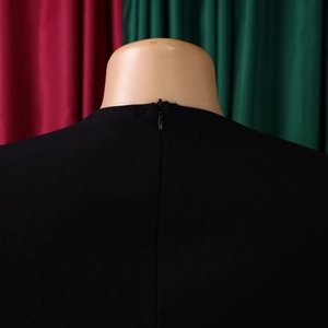 Detail of the high-quality invisible back zipper on this elegant black midi dress