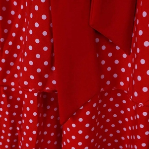 Detail of red and white polka dot dress fabric with layered design and fine stitching