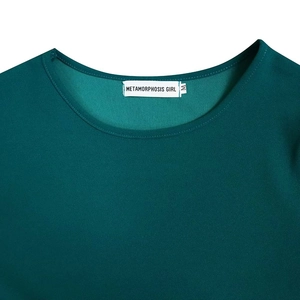 Detail of round neckline and woven brand label on dark green pleated dress