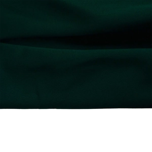 Detailed close-up of dark green dress fabric showing soft texture and premium quality