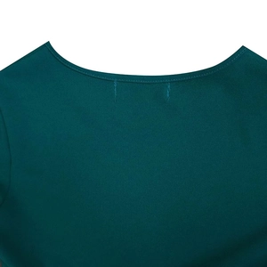 Detailed close-up of a dark green crew neck dress showing neat stitching and textured fabric