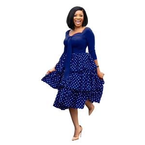 Close-up of long sleeve dress featuring bow tie neck and blue polka dot tiered skirt