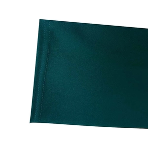 Detailed close-up of double-stitched seam on dark green textured short sleeve dress