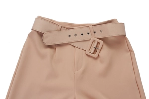 Detail of high waisted trousers with matching fabric belt and metallic eyelets
