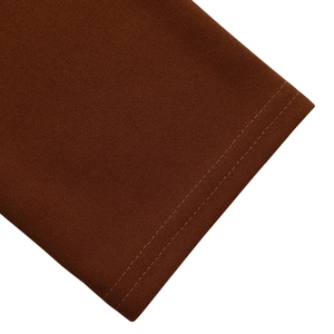 Detailed close-up showing durable double-needle stitching on caramel knit dress hem