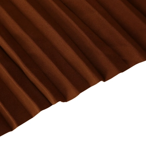 Macro view of brown pleated velvet fabric showing rich texture and vertical fold details
