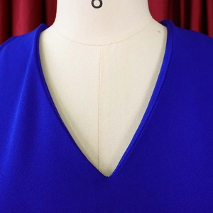Detail of royal blue V-neckline showing clean stitching and textured fabric on a mannequin