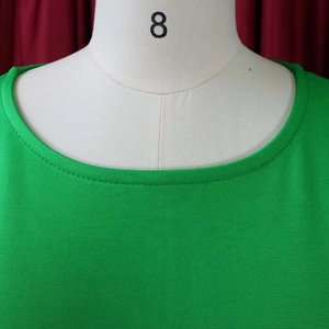 Close-up of the round neckline and smooth knit texture on this green bodycon dress